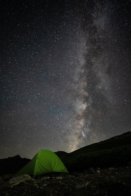 Green camping tent set up under the Milky Way in the desert mountains near Moab, Utah.