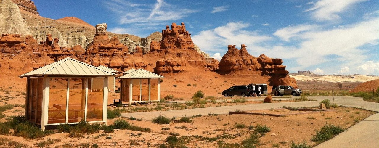 Desert campsite with tent set up against red rock mesa backdrop at sunset near Moab Utah